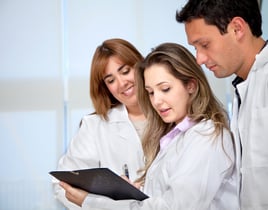 Group of doctors looking at a history chart indoors Group of doctors looking at a history chart indoors